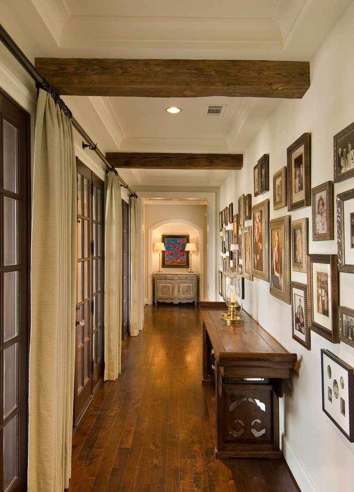 Photo of a traditional hallway in Houston with beige walls and medium hardwood floors.