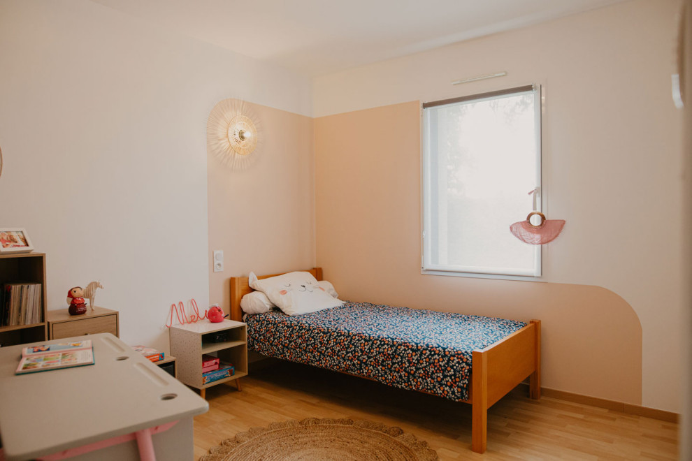 На фото: детская среднего размера в стиле кантри с спальным местом, розовыми стенами, полом из ламината и обоями на стенах для ребенка от 4 до 10 лет, девочки