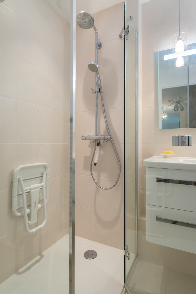 Photo of a small modern master bathroom in Paris with beaded inset cabinets, white cabinets, a curbless shower, white tile, cement tile, white walls, cement tiles, an undermount sink, tile benchtops, beige floor, a hinged shower door and white benchtops.