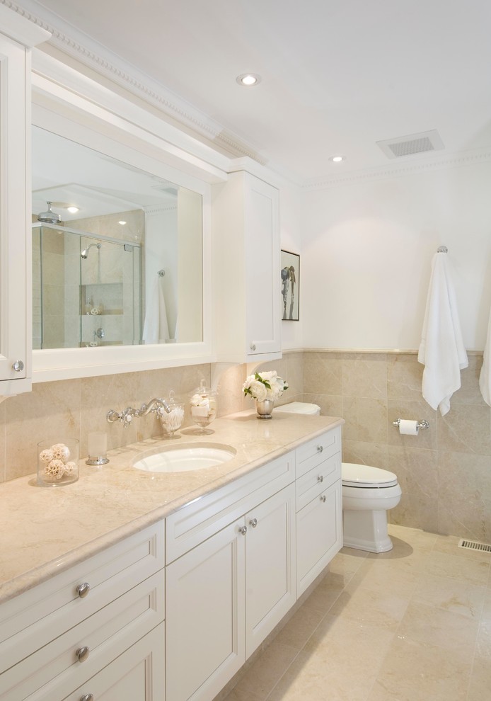 Design ideas for a mid-sized traditional 3/4 bathroom in Ottawa with an undermount sink, recessed-panel cabinets, white cabinets, beige tile, a one-piece toilet, ceramic tile, white walls, beige floor and beige benchtops.