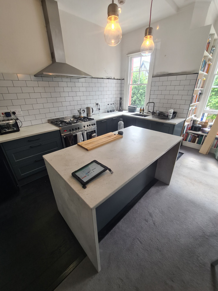 Mid-sized traditional l-shaped open plan kitchen in London with an integrated sink, shaker cabinets, white cabinets, quartzite benchtops, white splashback, ceramic splashback, panelled appliances, light hardwood floors, with island, black floor and multi-coloured benchtop.