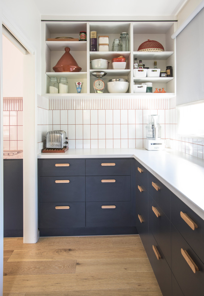 Design ideas for a mid-sized midcentury kitchen in Melbourne with a double-bowl sink, blue cabinets, white splashback, subway tile splashback and light hardwood floors.