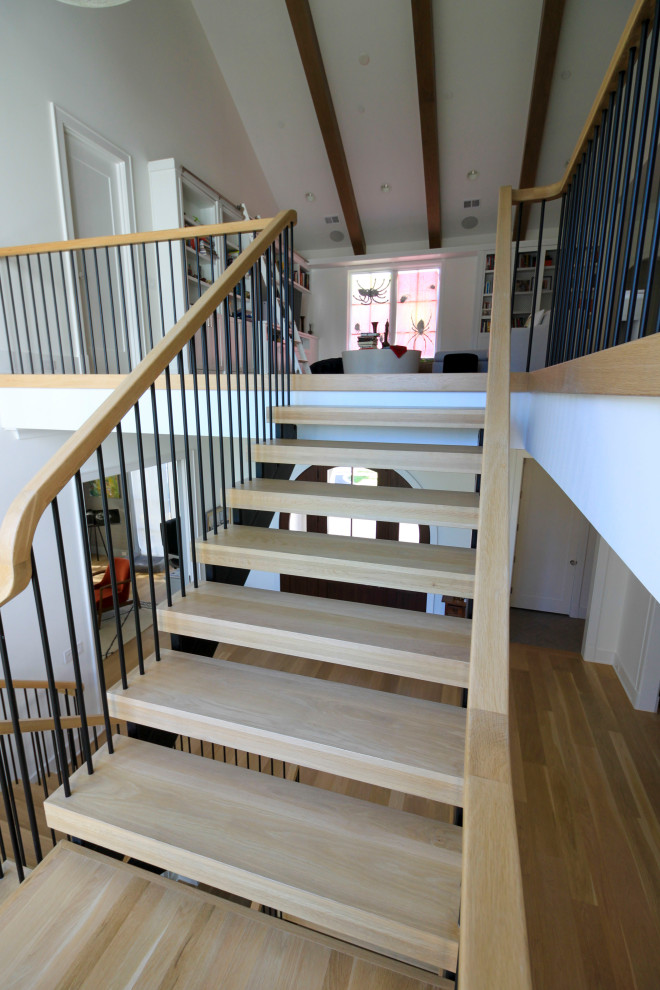Стильный дизайн: огромная лестница на больцах в стиле модернизм с деревянными ступенями, перилами из смешанных материалов и стенами из вагонки - последний тренд