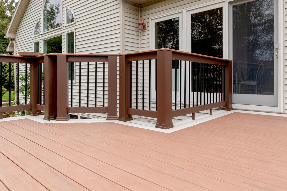Example of a mid-sized transitional backyard deck design with no cover