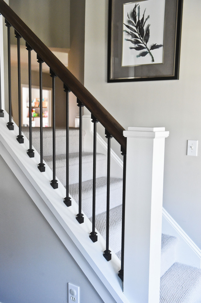 Foto de escalera recta clásica renovada grande con escalones enmoquetados, contrahuellas enmoquetadas, barandilla de metal y todos los tratamientos de pared