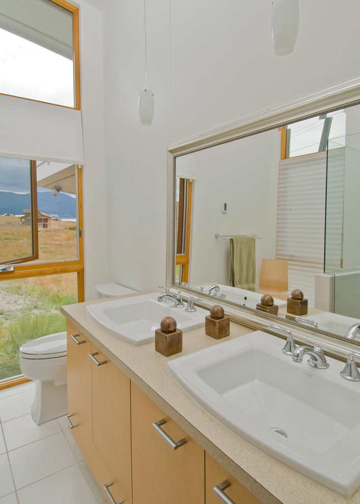 Mid-sized contemporary master bathroom in Vancouver with a drop-in sink, flat-panel cabinets, light wood cabinets, laminate benchtops, a two-piece toilet, white walls and ceramic floors.