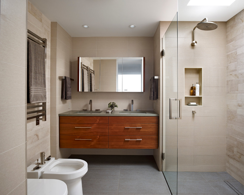 Photo of a modern bathroom in Philadelphia with an undermount sink, flat-panel cabinets, engineered quartz benchtops, beige tile, porcelain tile, porcelain floors, a curbless shower, a bidet and medium wood cabinets.