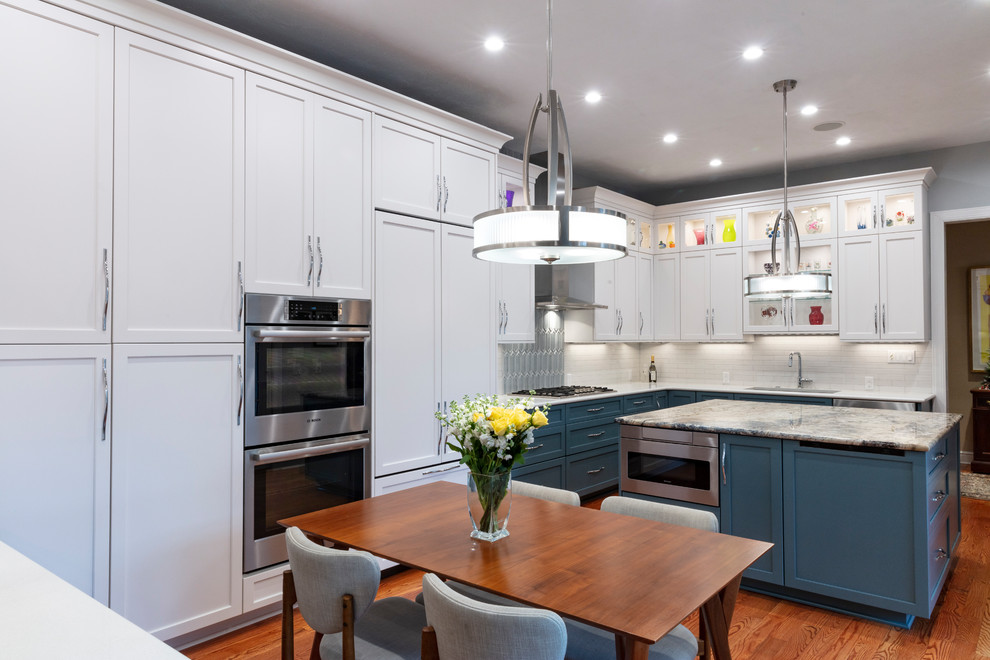 Transitional kitchen photo with white backsplash and stainless steel appliances