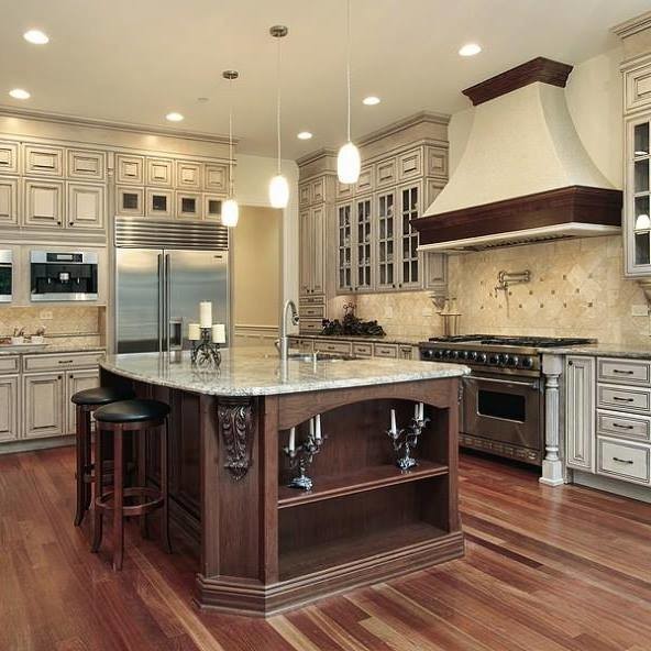 Photo of a large traditional l-shaped separate kitchen in Chicago with a double-bowl sink, raised-panel cabinets, white cabinets, granite benchtops, beige splashback, limestone splashback, stainless steel appliances, with island, brown floor and medium hardwood floors.