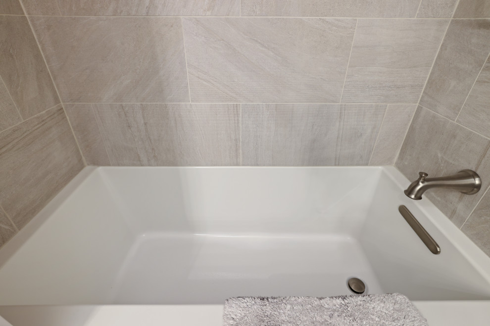 Bild på ett funkis vit vitt badrum för barn, med skåp i shakerstil, grå skåp, ett badkar i en alkov, en dusch/badkar-kombination, vinylgolv, ett undermonterad handfat, bänkskiva i kvarts, brunt golv och dusch med duschdraperi
