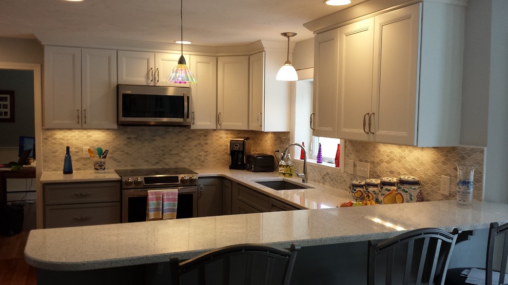 Kitchen - mid-sized transitional u-shaped kitchen idea in Boston with a single-bowl sink, gray cabinets, quartz countertops, gray backsplash, mosaic tile backsplash, stainless steel appliances and a peninsula