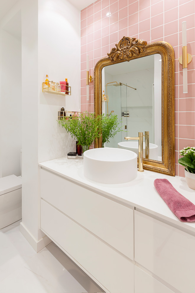 This is an example of a mid-sized contemporary master bathroom in Madrid with white cabinets, a curbless shower, pink tile, ceramic tile, white walls, marble floors, a vessel sink, white floor, a sliding shower screen, white benchtops and flat-panel cabinets.