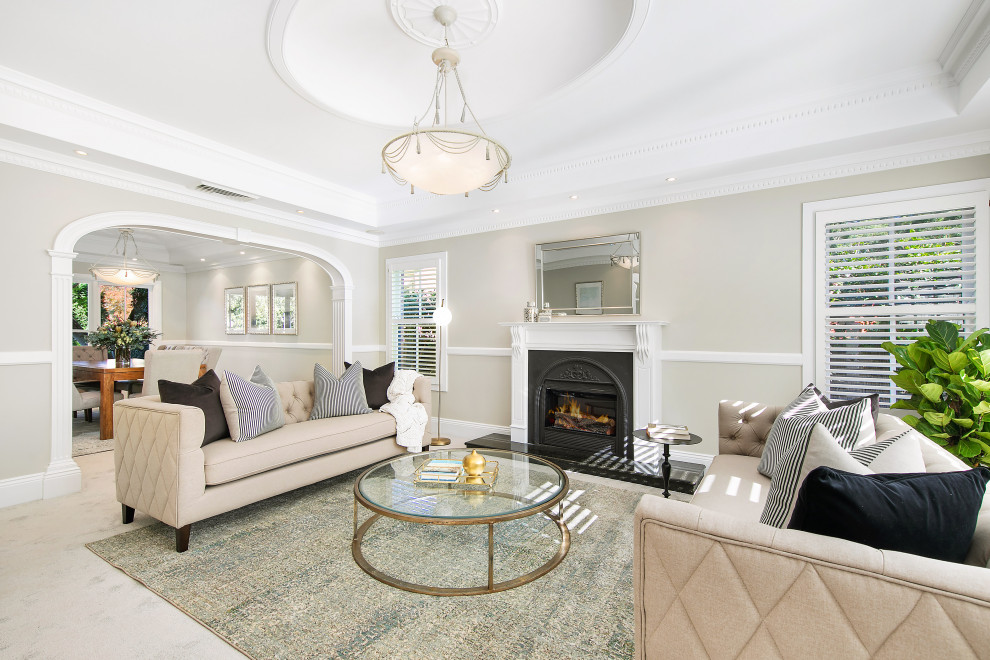 Design ideas for a mid-sized transitional formal enclosed living room in Sydney with grey walls, carpet, a standard fireplace, a plaster fireplace surround, beige floor and coffered.