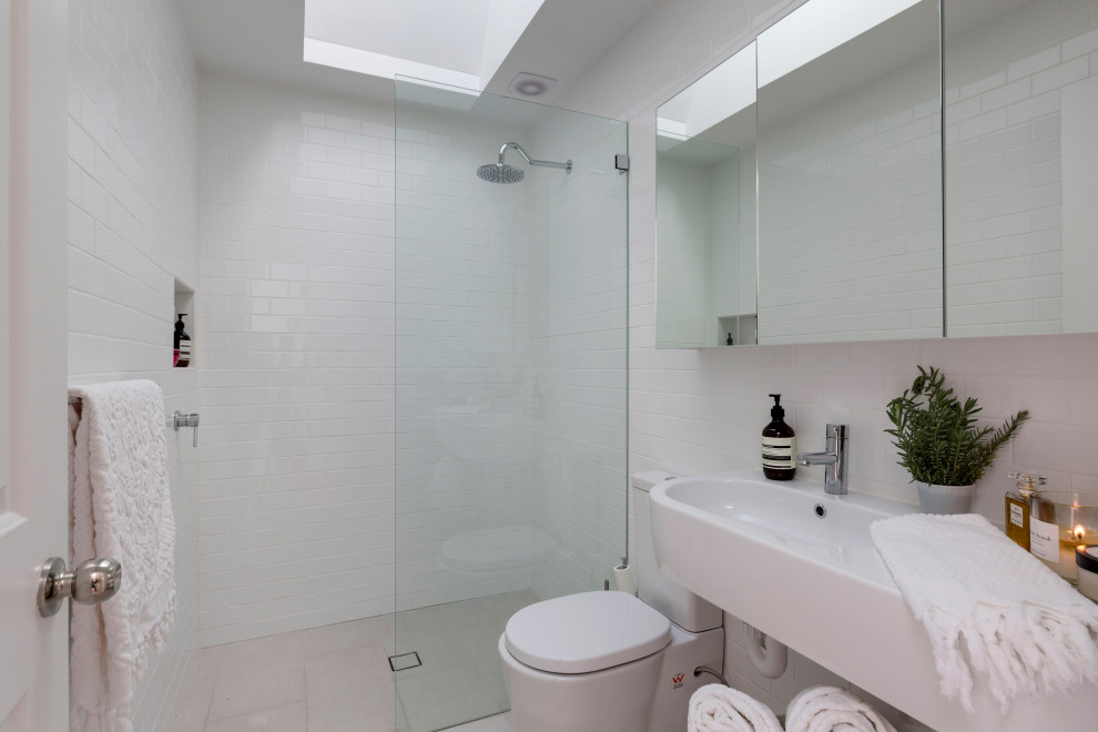 Contemporary bathroom in Sydney with a curbless shower, white tile, a wall-mount sink, grey floor, an open shower and a single vanity.