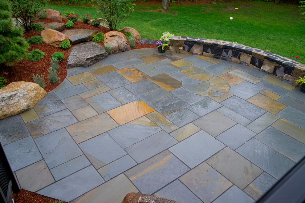Design ideas for a mid-sized country backyard patio in Boston with natural stone pavers and no cover.