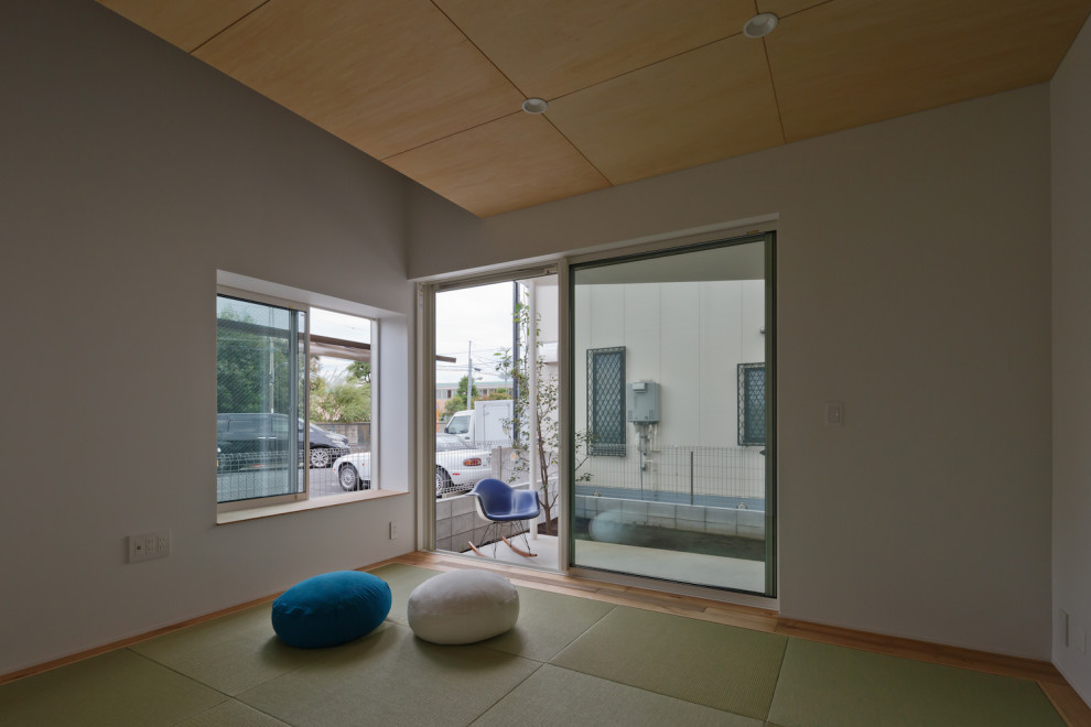 Small country master bedroom in Tokyo with white walls, tatami floors and green floor.