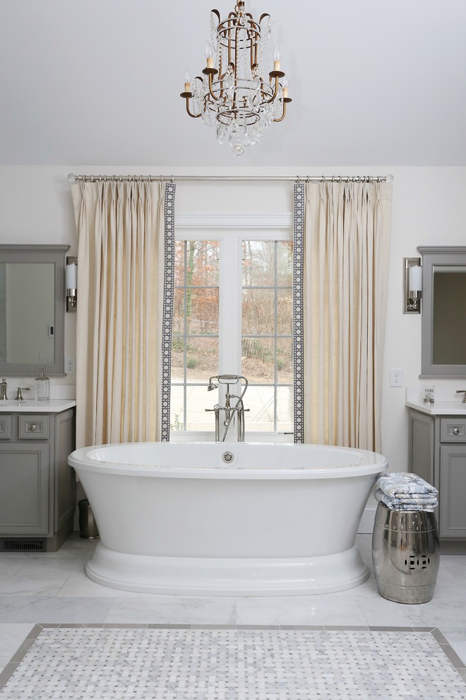 Design ideas for a large traditional master bathroom in Raleigh with shaker cabinets, grey cabinets, a freestanding tub, a double shower, a one-piece toilet, gray tile, marble, grey walls, marble floors, an undermount sink, marble benchtops, white floor, a hinged shower door, white benchtops, an enclosed toilet, a double vanity, a built-in vanity and vaulted.