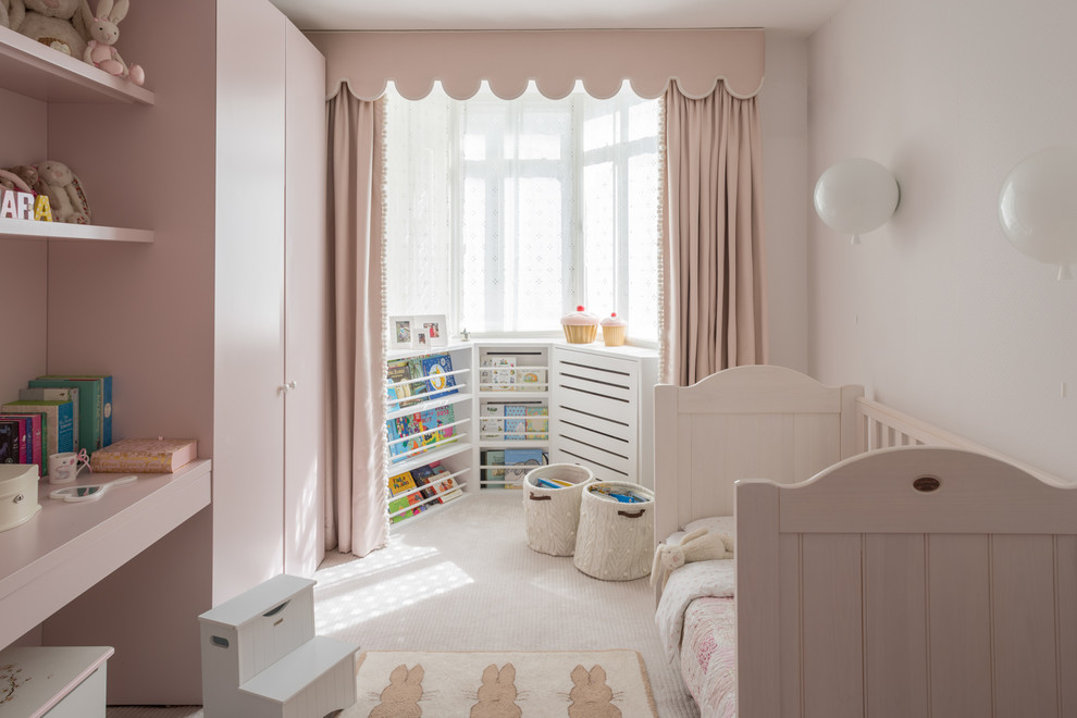 Photo of a mid-sized traditional kids' room for girls in London with pink walls, carpet and white floor.