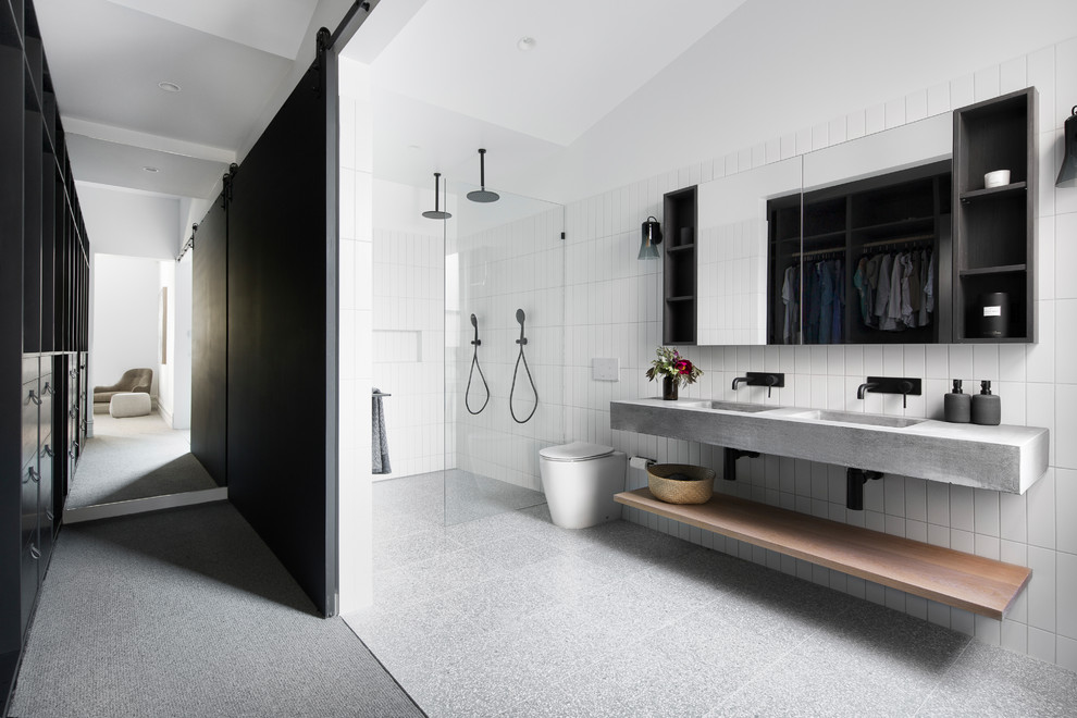Modern master bathroom in Melbourne with a curbless shower, a one-piece toilet, white tile, an integrated sink, concrete benchtops, grey floor, an open shower and grey benchtops.