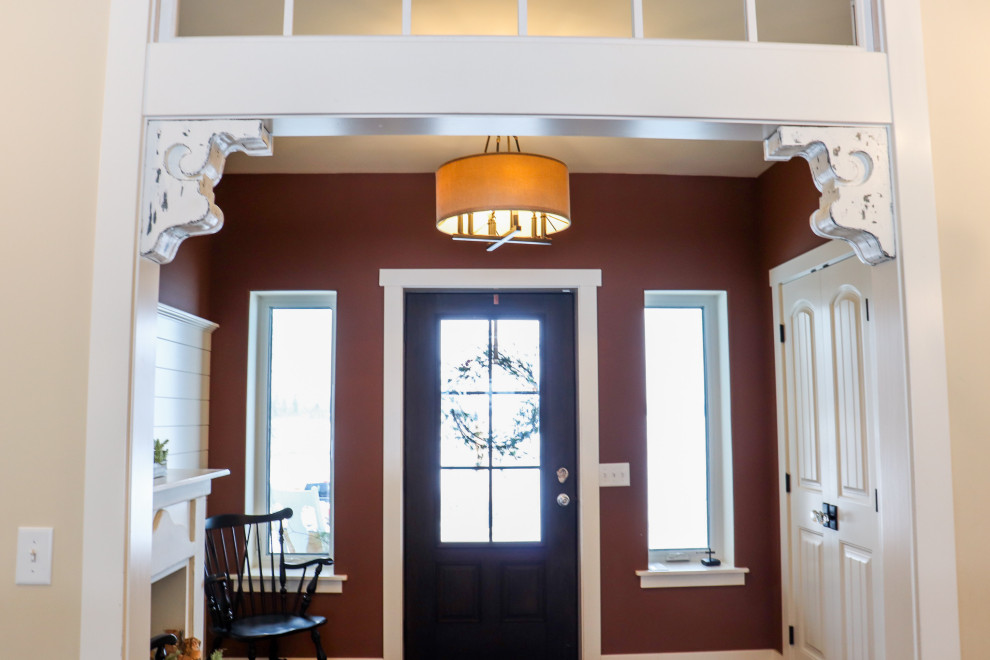 Photo of a medium sized traditional foyer in Grand Rapids with brown walls, light hardwood flooring, a single front door and a dark wood front door.