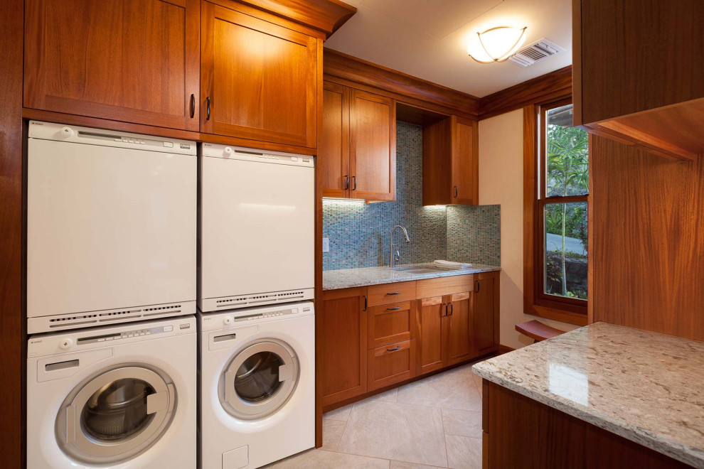 Diseño de cuarto de lavado de galera exótico de tamaño medio con fregadero bajoencimera, encimera de granito y lavadora y secadora juntas