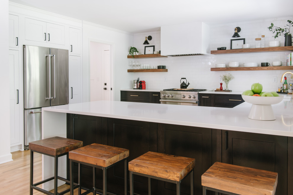 Kitchen - mid-sized transitional u-shaped kitchen idea in Atlanta with flat-panel cabinets, dark wood cabinets, white backsplash, subway tile backsplash, stainless steel appliances, a peninsula and white countertops