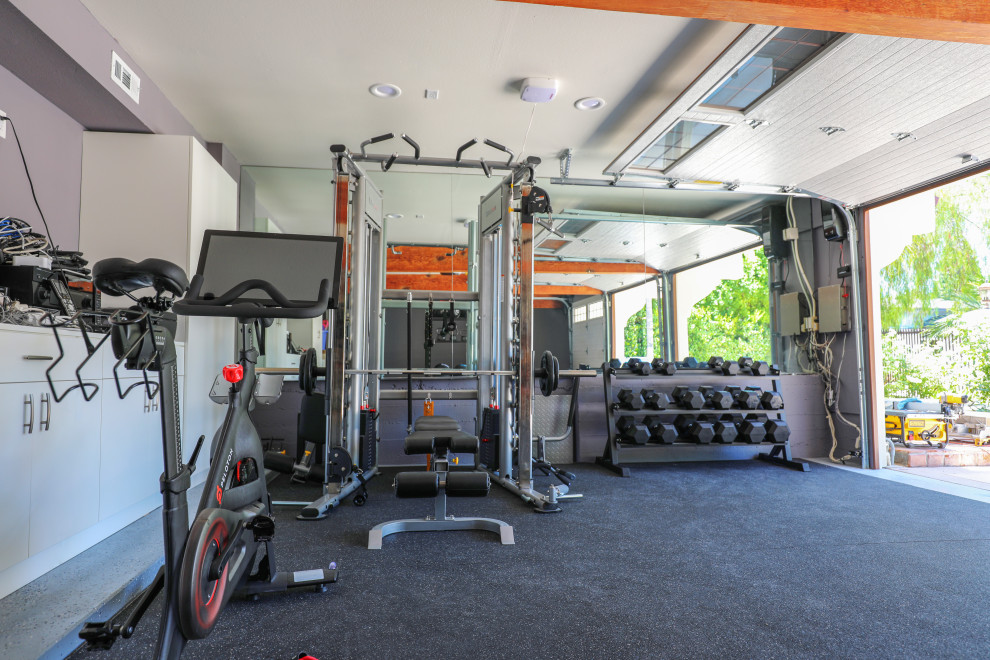 Inspiration for a mid-sized mediterranean home weight room in Orange County with white walls and black floor.