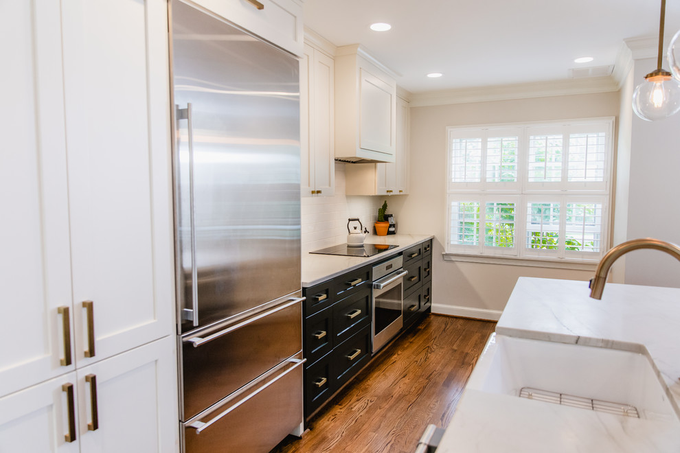Inspiration for a mid-sized contemporary single-wall eat-in kitchen in DC Metro with a farmhouse sink, shaker cabinets, white cabinets, marble benchtops, white splashback, subway tile splashback, stainless steel appliances, dark hardwood floors, with island, brown floor and white benchtop.