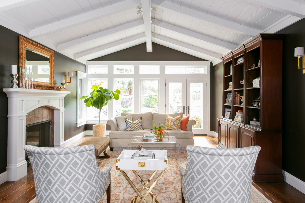 Example of a classic medium tone wood floor and brown floor living room design in San Francisco with brown walls and a standard fireplace