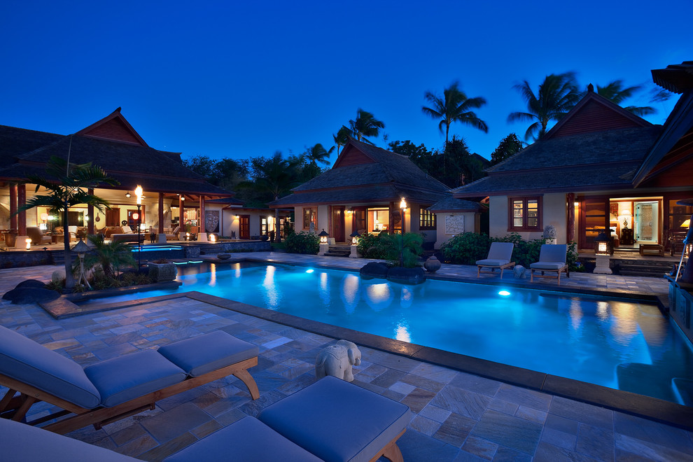Mid-sized asian courtyard rectangular infinity pool in Hawaii with a hot tub and natural stone pavers.