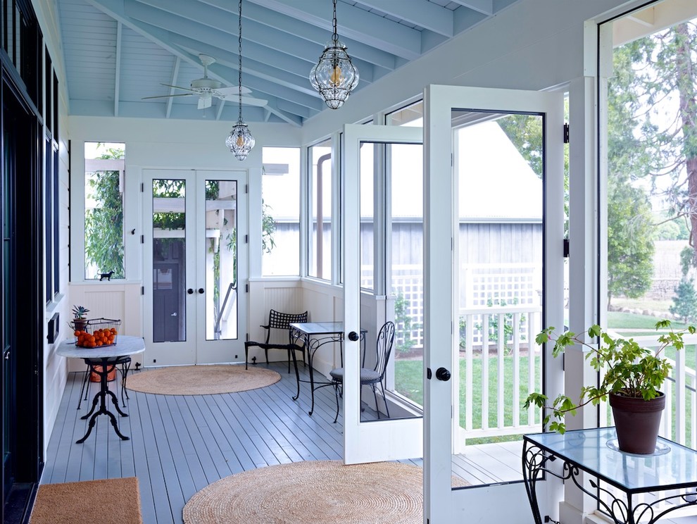 This is an example of a large traditional backyard screened-in verandah in San Francisco with decking and a roof extension.