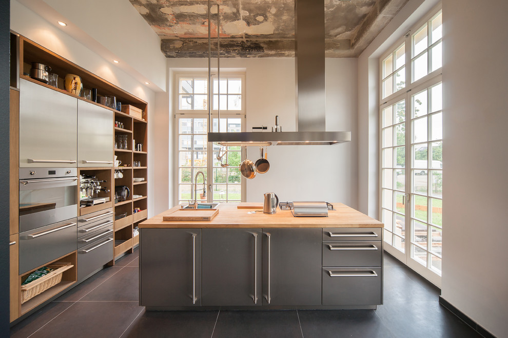 Inspiration for a large industrial separate kitchen in Leipzig with open cabinets, stainless steel cabinets, wood benchtops, stainless steel appliances, with island and a drop-in sink.
