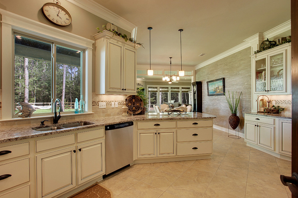 This is an example of a mid-sized traditional kitchen in New Orleans with an undermount sink, raised-panel cabinets, beige cabinets, granite benchtops, beige splashback, terra-cotta splashback, stainless steel appliances and porcelain floors.