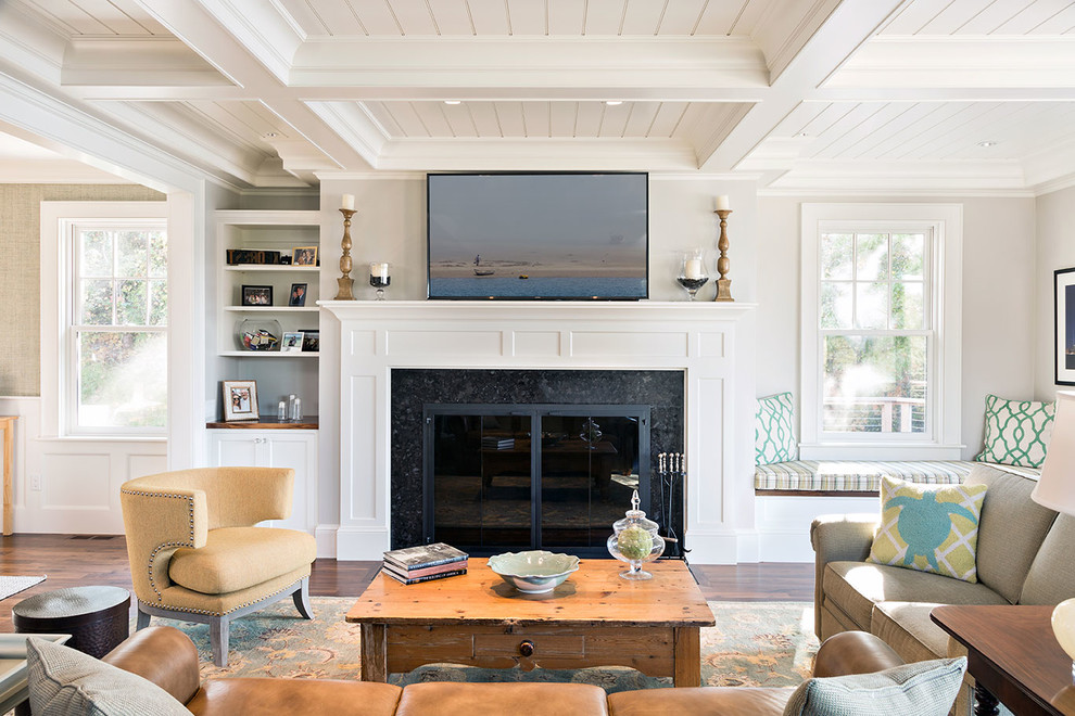 Photo of a mid-sized beach style enclosed family room in Boston with beige walls, dark hardwood floors, a standard fireplace, a stone fireplace surround and brown floor.
