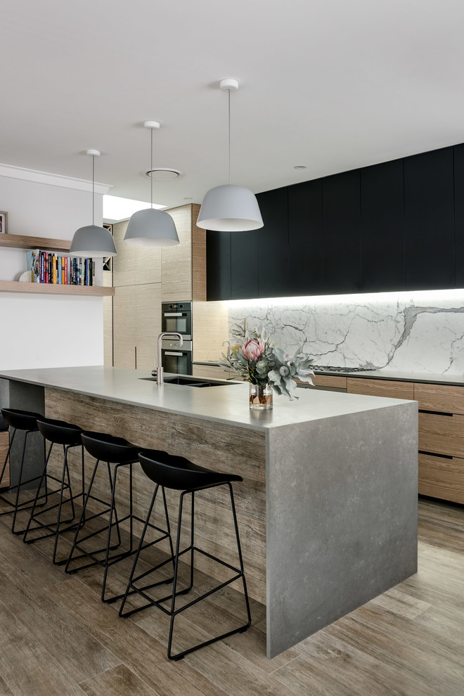 Design ideas for a mid-sized contemporary galley kitchen in Perth with a double-bowl sink, flat-panel cabinets, metallic splashback, marble splashback, black appliances, with island and brown floor.