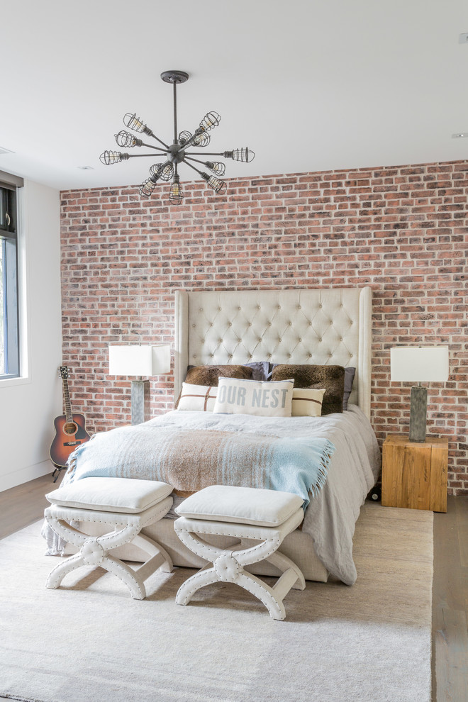 Photo of a large industrial guest bedroom in Toronto with white walls and light hardwood floors.