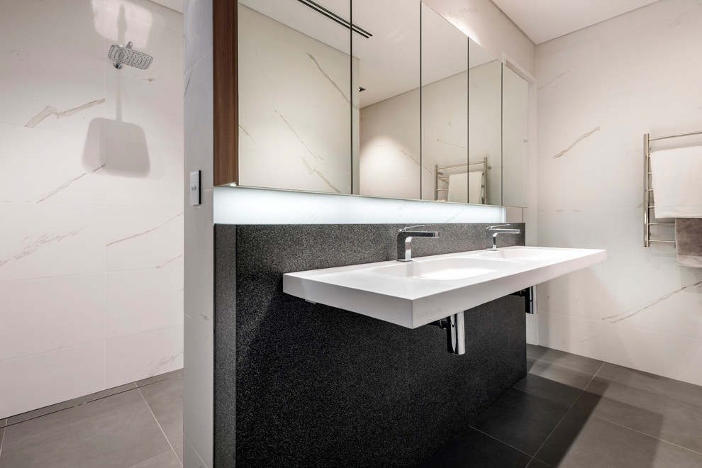 Contemporary bathroom in Perth with a wall-mount sink, furniture-like cabinets, medium wood cabinets, engineered quartz benchtops, white tile, porcelain tile, white walls and porcelain floors.
