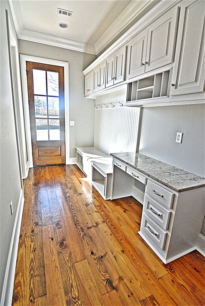 Inspiration for a mid-sized transitional medium tone wood floor and brown floor mudroom remodel in Jackson with gray walls and a medium wood front door
