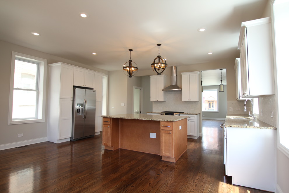 Large transitional u-shaped medium tone wood floor open concept kitchen photo in Chicago with an undermount sink, shaker cabinets, white cabinets, granite countertops, gray backsplash, stone tile backsplash, stainless steel appliances, gray walls and an island