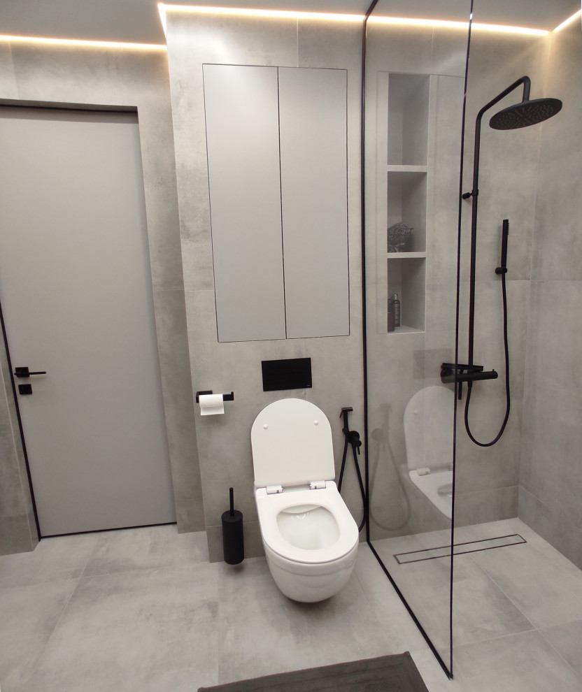 Идея дизайна: серо-белая ванная комната среднего размера в современном стиле с фасадами цвета дерева среднего тона, отдельно стоящей ванной, душем без бортиков, инсталляцией, серой плиткой, керамогранитной плиткой, серыми стенами, бетонным полом, душевой кабиной, подвесной раковиной, столешницей из гранита, серым полом, шторкой для ванной, серой столешницей, зеркалом с подсветкой, тумбой под одну раковину и подвесной тумбой