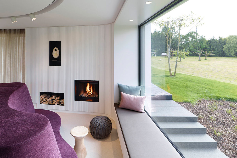 Large contemporary living room in Stuttgart with white walls, a standard fireplace and beige floor.