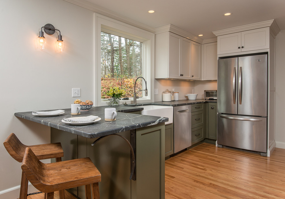 Inspiration for a mid-sized transitional l-shaped eat-in kitchen remodel in Boston with recessed-panel cabinets, green cabinets, soapstone countertops, white backsplash, subway tile backsplash, stainless steel appliances and a peninsula