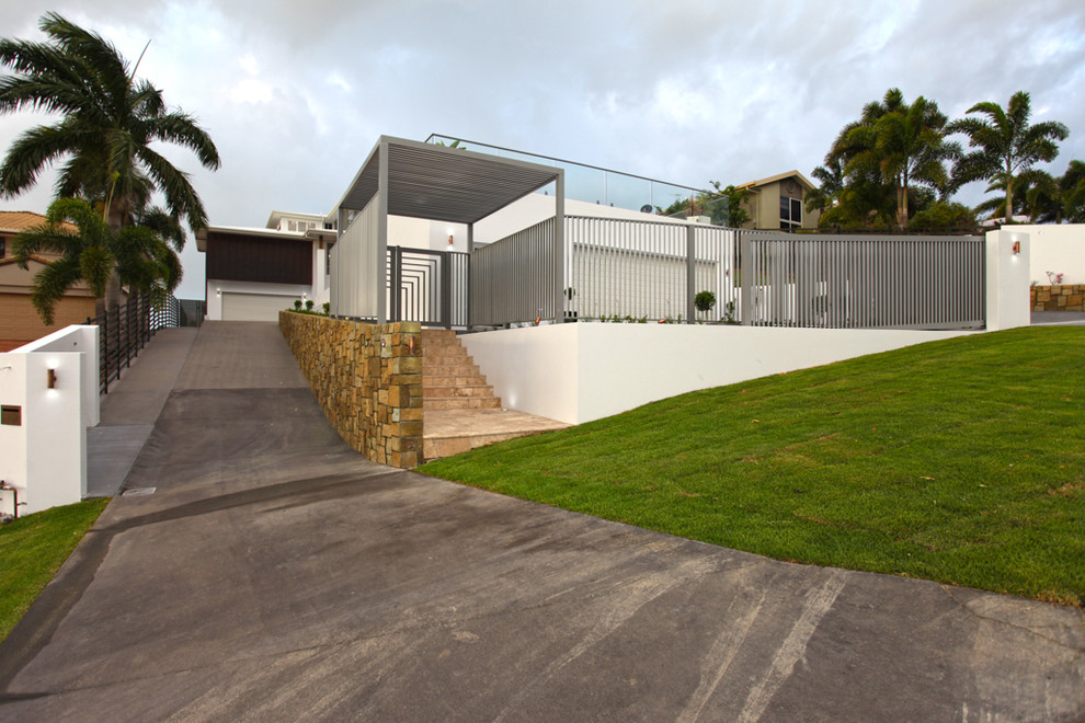 Photo of a large contemporary three-storey white exterior in Brisbane with stone veneer and a flat roof.