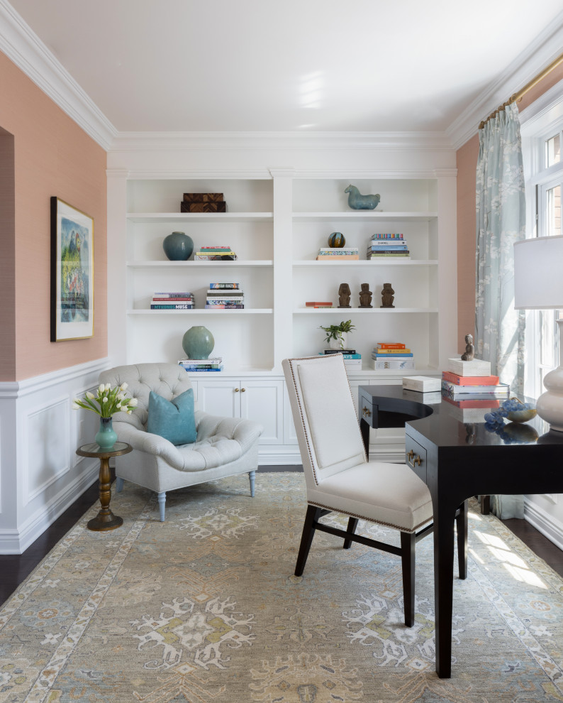 Imagen de despacho tradicional pequeño sin chimenea con paredes rosas, suelo de madera oscura, escritorio independiente, suelo marrón y papel pintado
