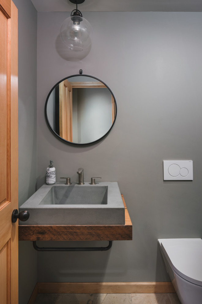 Cette image montre un WC et toilettes design de taille moyenne avec WC à poser, un mur gris, un sol en carrelage de porcelaine, une vasque, un plan de toilette en bois, un sol multicolore, un plan de toilette marron et meuble-lavabo suspendu.