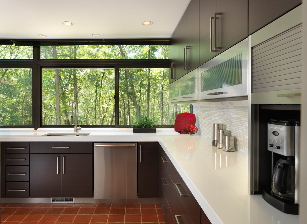 Design ideas for a mid-sized modern l-shaped separate kitchen in Providence with an undermount sink, flat-panel cabinets, dark wood cabinets, quartz benchtops, grey splashback, matchstick tile splashback, stainless steel appliances, terra-cotta floors and no island.