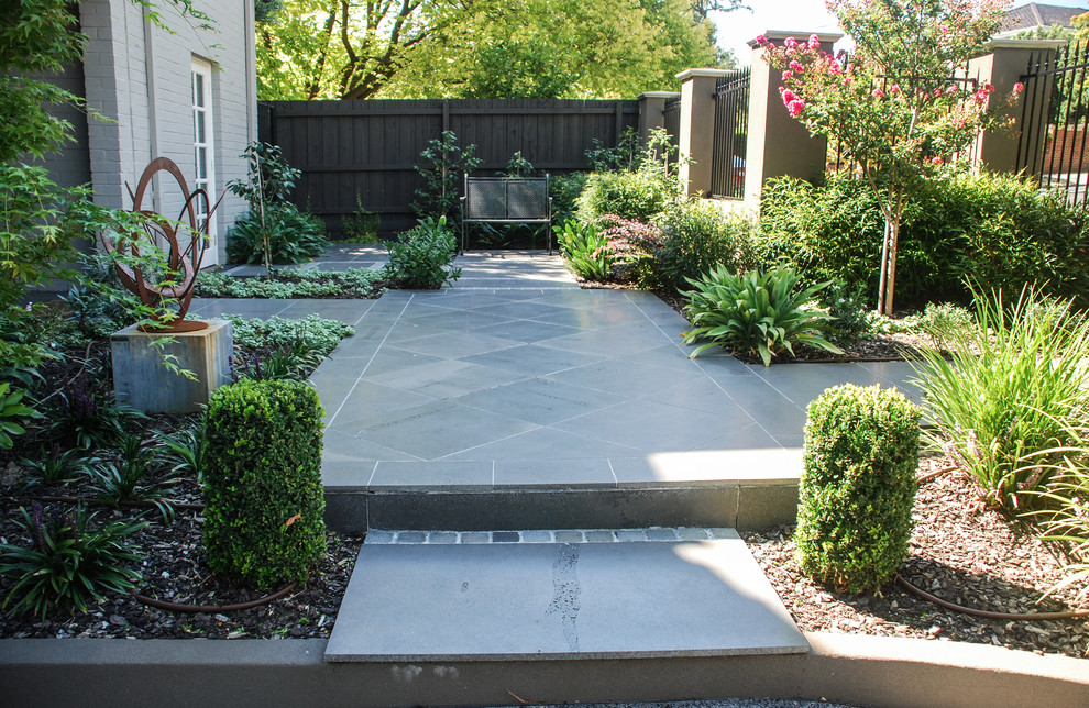 Mid-sized contemporary front yard partial sun formal garden in Melbourne with natural stone pavers.