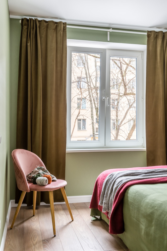 Пример оригинального дизайна: маленькая хозяйская спальня в скандинавском стиле с зелеными стенами, полом из ламината, коричневым полом, обоями на стенах и акцентной стеной для на участке и в саду