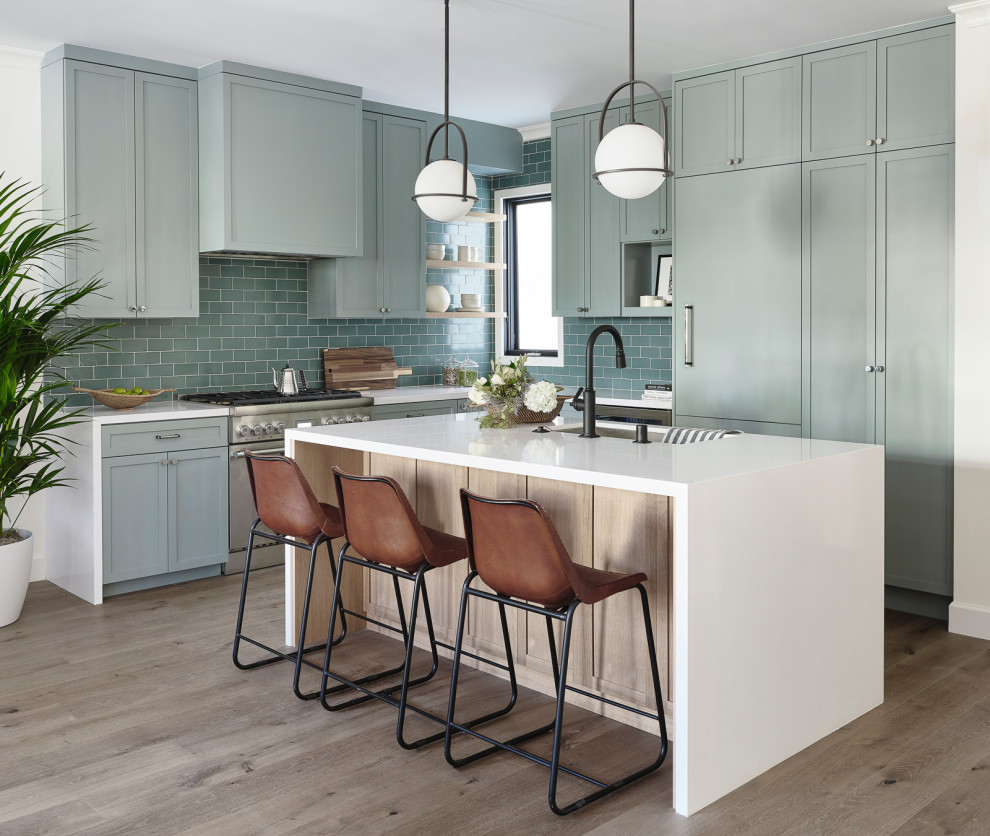 Design ideas for a mid-sized transitional l-shaped open plan kitchen in San Francisco with shaker cabinets, green cabinets, quartz benchtops, green splashback, ceramic splashback, panelled appliances, with island, white benchtop, an undermount sink, medium hardwood floors and brown floor.