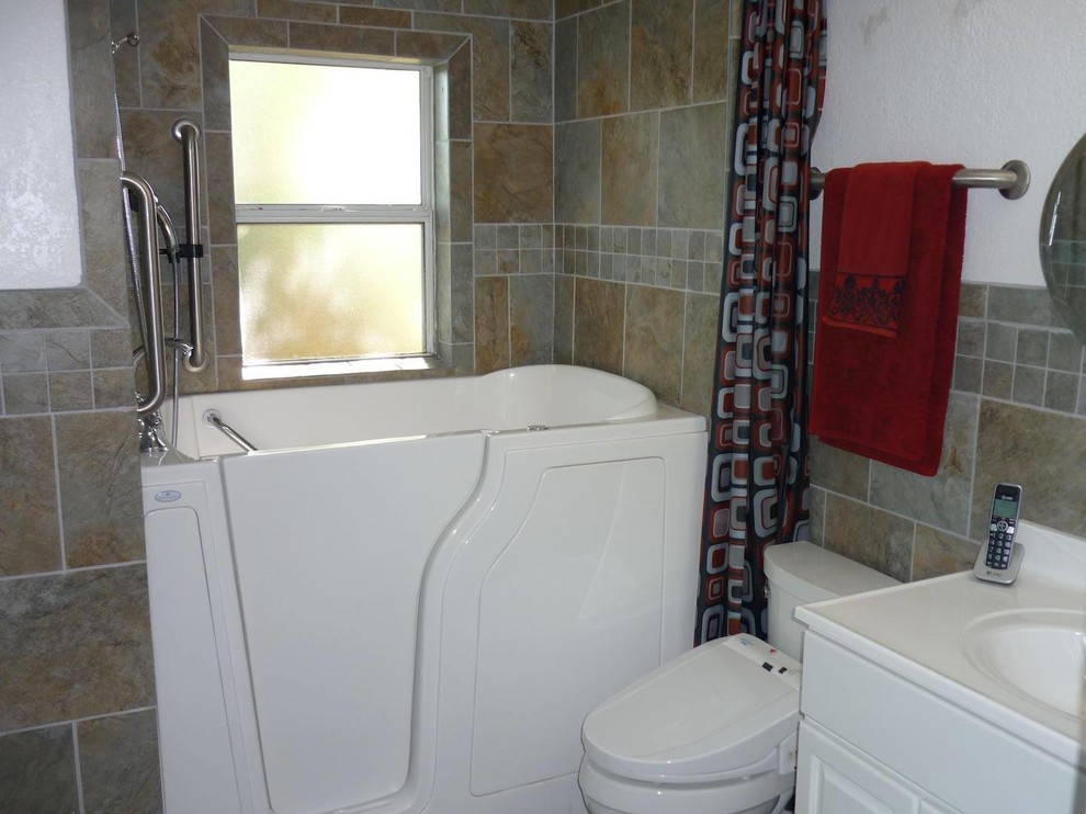Mid-sized contemporary 3/4 bathroom in Denver with a corner tub, a shower/bathtub combo, raised-panel cabinets, white cabinets, a bidet, multi-coloured tile, slate, white walls, an integrated sink, laminate benchtops and a shower curtain.